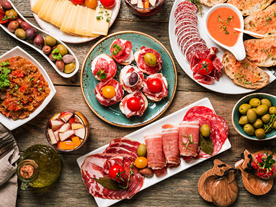 A table with different types of spanish food on them at a hen dinner in Madrid