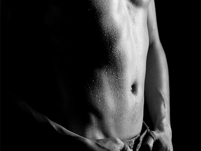 A man performing a strip tease in dark lighting in Madrid