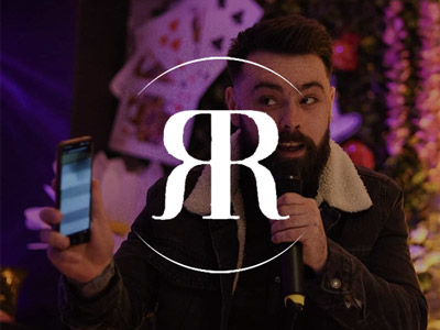 Someone singing with a microphone in one hand and a phone in the other at the River Rooms in Belfast