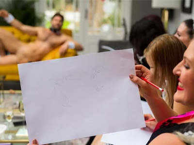 A girl holding her drawing of a nude man up at Mobile Nude Life Drawing