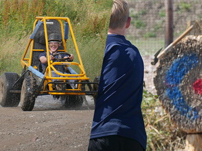  A split image of someone driving a dirt kart and someone throwing an axe at a wooden target