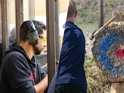 A split image of someone wearing ear defenders and safety glasses and someone throwing an axe at a target