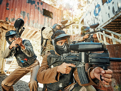 Two people paintballing wearing safety glasses and camo outfits in Lisbon