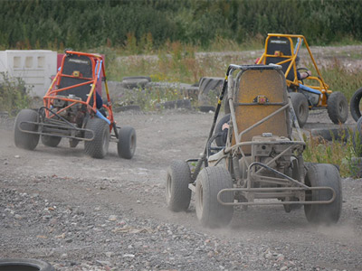 Three people in off road karts on a dirt track with Hover Force Ltd