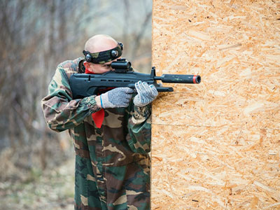 Someone playing combat laser with orange lighting behind him at Outdoor Laser Combat in Madrid