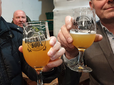Two people with pints in their hands at a Liverpool Brewery Tour