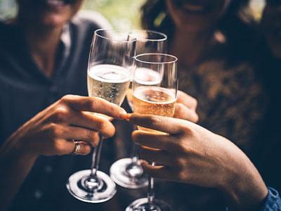 Three people clinking glasses of fizz 