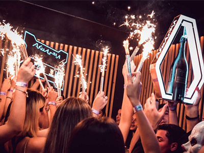 People with sparklers and bottles of alcohol at Akuarela in Valencia