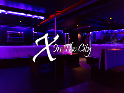 A purple lit room with a pole in the middle at X in the City in Liverpool