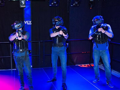 Group of guys wearing VR goggles and holding a gun controller