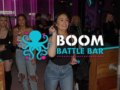 A girl aiming a dart at a board at Boom Battle Bar
