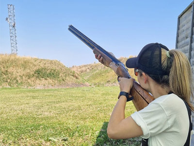 A woman aiming a gun at a clay pigeon at clay pigeon shooting in Dublin