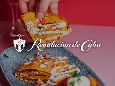 Someone picking up a tortilla covered in a dressing at Revolucion De Cuba 