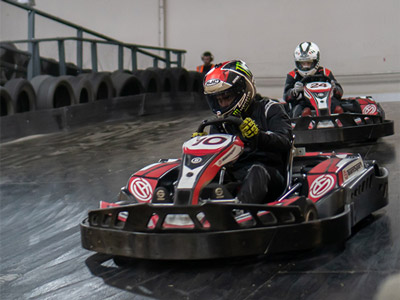 Two stags on gokarts racing around an indoor Grand Prix track in Dublin