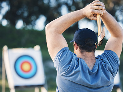 Someone throwing an axe at a target outdoors in Lisbon