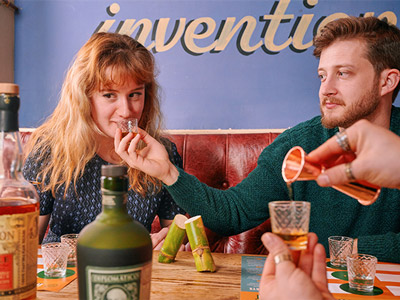 Two people smelling and tasting a selection of different rum