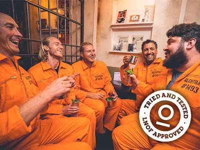 A group of boys drinking cocktails in orange prison jumpsuits