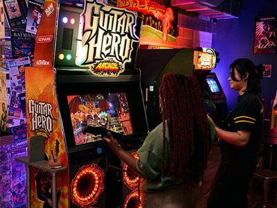 Two girls playing Guitar Hero at Four Quarters