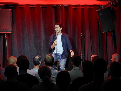 Someone performing a comedy show on stage at Comedy Club