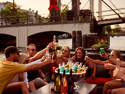 A group of friends on a canal boat cruise with beers in hand 
