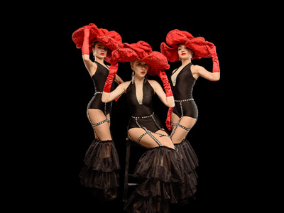 Three people dressed in burlesque costumes at a burlesque dance class