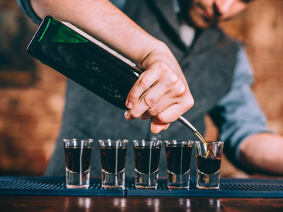 A bartender pouring out 5 shots on a private bar crawl