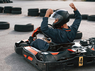Someone on a kart with his arms in the air