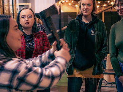Two people posing with axes in hand