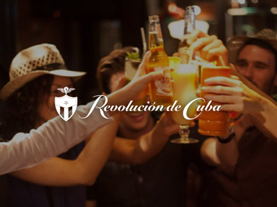Several people clinking colourful cocktails with the Revolucion de Cuba logo layered over it 