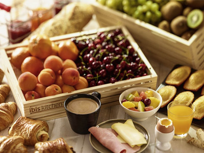 A selection of breakfast food including fruit, eggs, coffee and pastries 