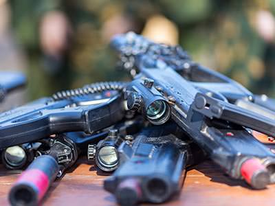 A number of laser tag guns lying on a wooden surface