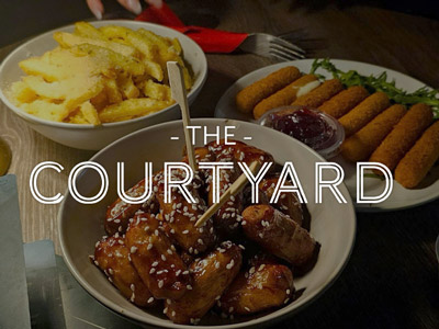 Several dishes of food with The Courtyard layered over it 