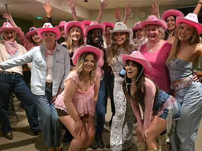 A hen do group wearing custom cowboy hats posing for a group pic 