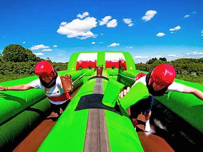 Two people running on a bouncy castle 