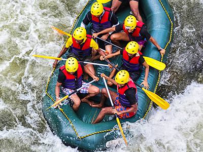 Seven people in a rubber dinghy, battling white water rapids