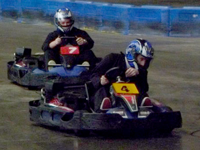 A close up of a man in a blue bodysuit, sat in a go kart