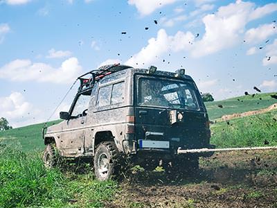 A large 4x4 driving through a muddy field