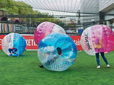 A team of people in inflatable bubbles playing bubble football