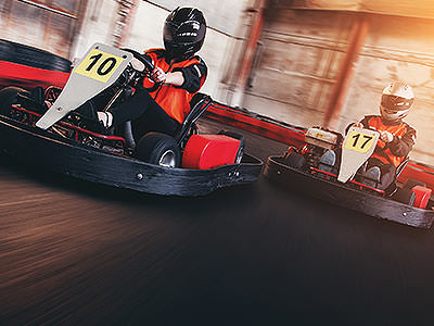 Two go karts race on an indoor circuit