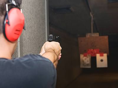 A man aiming a handgun at a target