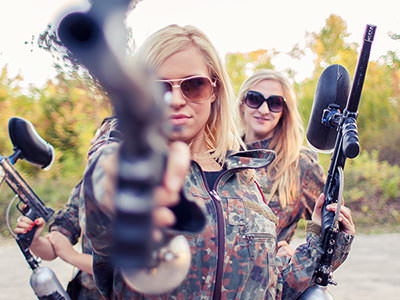 Some girls holding guns and wearing camouflague 