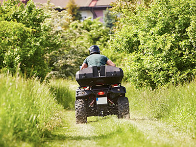 A man driving a quad bike into the wilderness