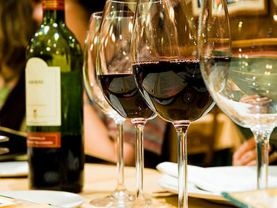 Two bottles of red wine and white wine in the foreground, with half a bottle of red in the background