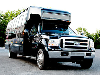 A black hummer outdoors to a backdrop of trees