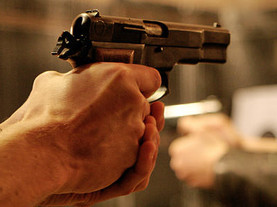 A man's hands aiming with a pistol