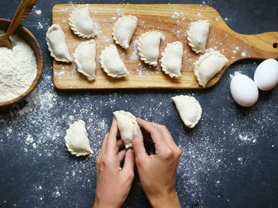 A pair of hands making Pierogis 