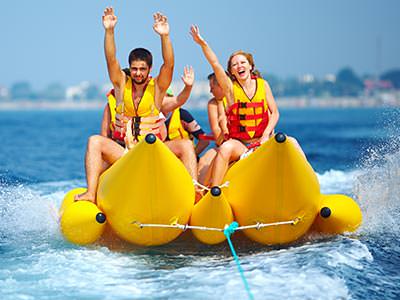 Some people sitting on a banana boat, riding across the water