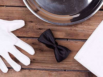 A glove and a bow tie on a wooden table 