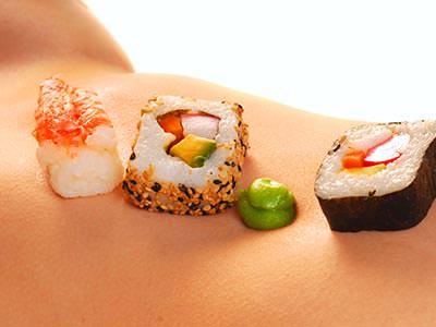 Close up of sushi on a naked woman's stomach