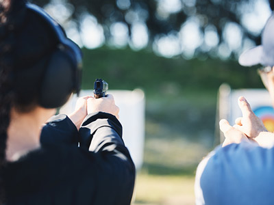A person aiming a sub-machine gun away